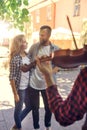 Young loving couple enjoying street musician with a violin Royalty Free Stock Photo