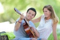 young loving couple with guitar in field