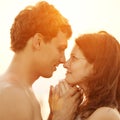 A young loving couple hugging and kissing on the beach at suns Royalty Free Stock Photo