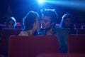 Young loving couple kissing at the cinema