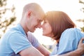 Young loving couple outdoors sitting on grass, hugging and looking on each other with love. Royalty Free Stock Photo