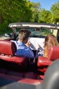 Young loving couple planning their romantic adventure. Joyful young couple smiling while riding in their convertible Royalty Free Stock Photo