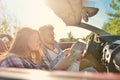 Young loving couple planning their romantic adventure. Joyful young couple smiling while riding in their convertible Royalty Free Stock Photo