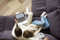 Young couple sitting on couch embracing holding laptop, top view Royalty Free Stock Photo