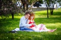 Young loving couple sitting at park on the grass in spring Royalty Free Stock Photo