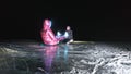 Young loving couple skating at ice rink at night. Man and woman kiss hug have fun learn to skate. Making love on ice Royalty Free Stock Photo