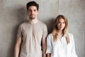 Young loving couple standing over grey wall Royalty Free Stock Photo