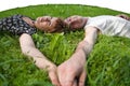 Young loving couple teenagers laying on green gras