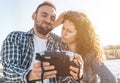 Young loving couple on vacation at the beach takes a funny selfie with an instant camera - Boyfriend and girlfriend share their Royalty Free Stock Photo