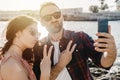 Young loving couple on vacation at the beach takes a funny selfie with smartphone - Boyfriend and girlfriend share their moments Royalty Free Stock Photo