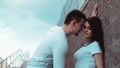 Young loving couples standing next to the brick wall, happy and satisfied Royalty Free Stock Photo