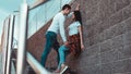 Young loving couples standing next to the brick wall, happy and satisfied Royalty Free Stock Photo