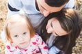 Young loving family of three, authentic candid outdoors family portrait. Royalty Free Stock Photo