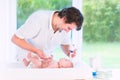 Young loving father changing diaper of newborn son Royalty Free Stock Photo