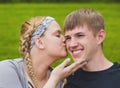 Young loving girl kissing her boyfriend on cheek Royalty Free Stock Photo