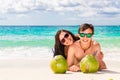 Young loving happy couple have fun on tropical beach, with coconuts. Summer vacation concept. Royalty Free Stock Photo