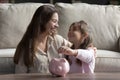 Little child put coins into piggy bank Royalty Free Stock Photo