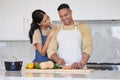 A young loving latin couple cooking a healthy dinner together at home. A loving man cutting carrots and other vegetable