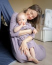 Loving mom and son infant playing together while sitting near tipi in kids room Royalty Free Stock Photo