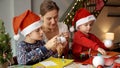 Young loving mother with kids making handmade Christmas baubles for decorating house. Winter holidays, family time Royalty Free Stock Photo