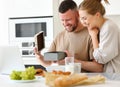 Young loving wife making surprise for husband on Birthday while standing in kitchen at home