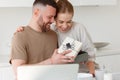 Young loving wife making surprise for husband on Birthday while standing in kitchen at home