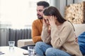 Young loving wife supporting her depressed husband during psychotherapy session with counselor, free space Royalty Free Stock Photo