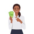 Young lucky girl hold lot of money, pointing at dollar bills in hand and smiling excitedly