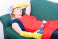 Young maid with cleaning spray laying on couch