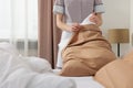 Young maid making bed in hotel room, closeup Royalty Free Stock Photo