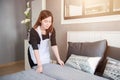 Young maid tidying up bed in hotel room, Cleaning service concept Royalty Free Stock Photo