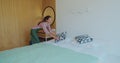 Young maid tidying up bed in hotel room, Cleaning service concept. Royalty Free Stock Photo