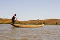 Young Malagasy rafter man rowing traditional canoe