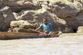 Young Malagasy rafter man rowing traditional canoe