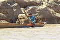 Young Malagasy rafter man rowing traditional canoe