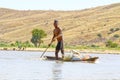 Young Malagasy rafter man rowing traditional canoe