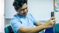 Young Malay man smile and taking a selfie with his smartphone Royalty Free Stock Photo