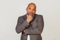 Young male African American businessman holding his chin with thoughtful facial expression looking into the camera. The guy is Royalty Free Stock Photo