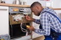 Technician Fixing Dishwasher With Digital Multimeter