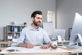 Young male architect, designer making drawings and project on whatman paper on desk in his office. Sitting at a table, with a Royalty Free Stock Photo