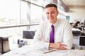 Young male architect sitting at his desk, looking to camera Royalty Free Stock Photo