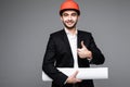 Young male architect wearing helmet and holding blueprints Royalty Free Stock Photo