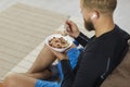 Young male athlete is having a bowl of healthy granola after his fitness workout Royalty Free Stock Photo