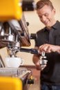 Young male barista making coffee. Royalty Free Stock Photo