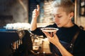 Young male barista sniffs fresh coffee beans