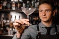 Young male barman holding a clear cocktail glass Royalty Free Stock Photo