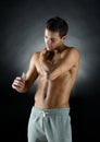 Young male bodybuilder applying pain relief gel