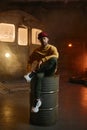 Young male breakdancer sitting on steel barrel tank Royalty Free Stock Photo