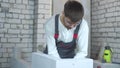 Young male builder checking evenness of aerated concrete wall