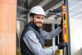 young male builder uses spirit level